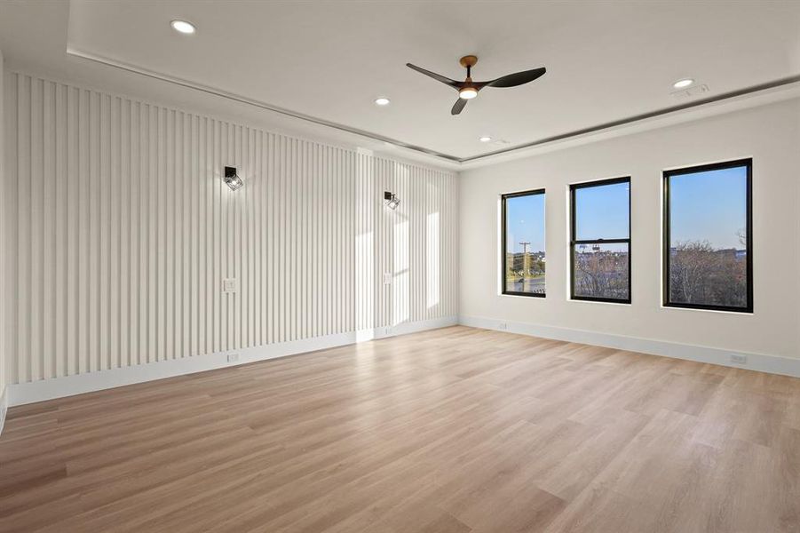 Empty room with ceiling fan and light hardwood / wood-style floors