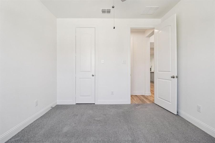Unfurnished bedroom featuring light colored carpet and baseboards Unfurnished bedroom featuring light colored carpet and baseboards