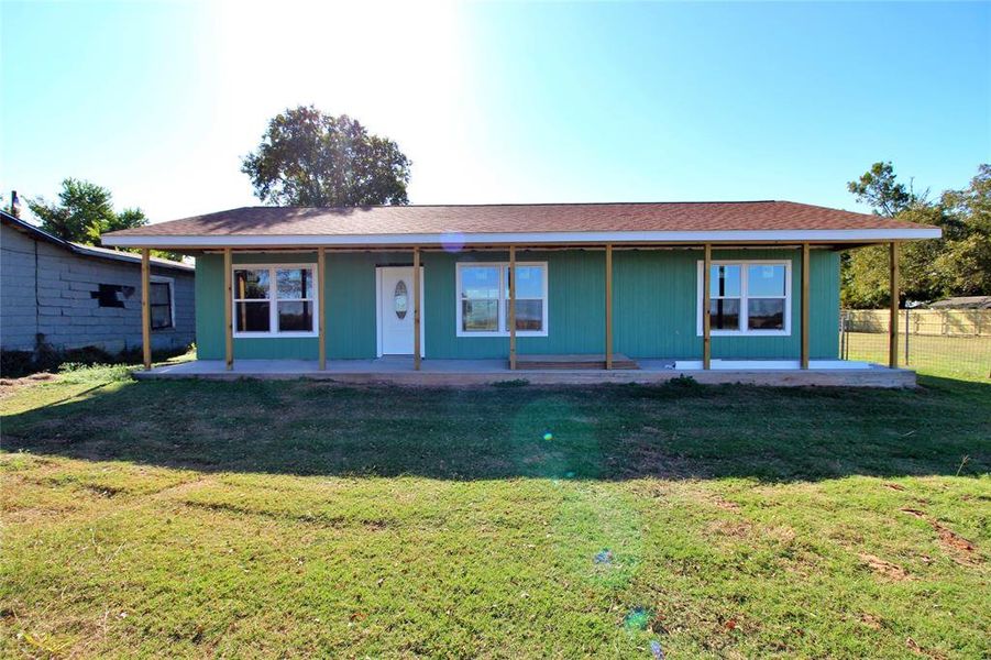 View of front facade featuring a shingled roof and a porch View of front facade featuring a shingled roof and a porch