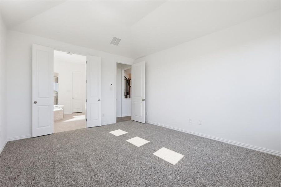 Unfurnished bedroom featuring light carpet and baseboards
