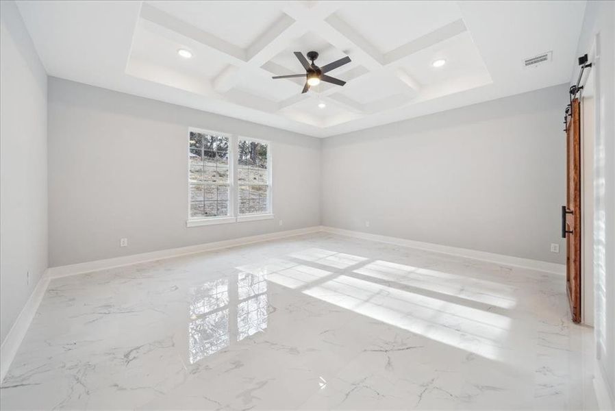 Empty room with ceiling fan, coffered ceiling, and beamed ceiling