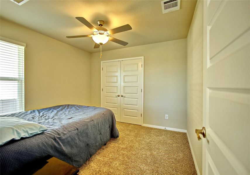 Bedroom with light colored carpet, a ceiling fan, and a closet Bedroom with light colored carpet, a ceiling fan, and a closet