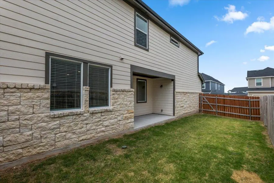 A well-maintained fenced yard complements the home's stone and siding exterior, offering a pleasant outdoor space.