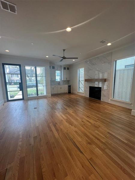 Unfurnished living room featuring a healthy amount of sunlight, hardwood / wood-style floors, and a fireplace