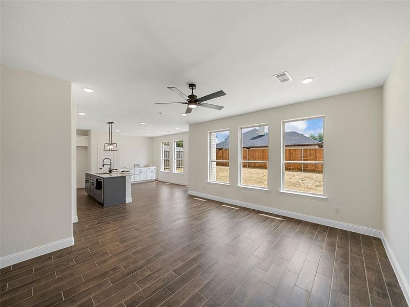 Unfurnished living room featuring ceiling fan and sink