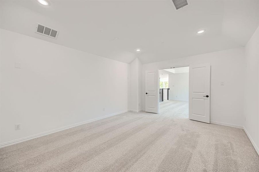 Spare room featuring lofted ceiling and light colored carpet