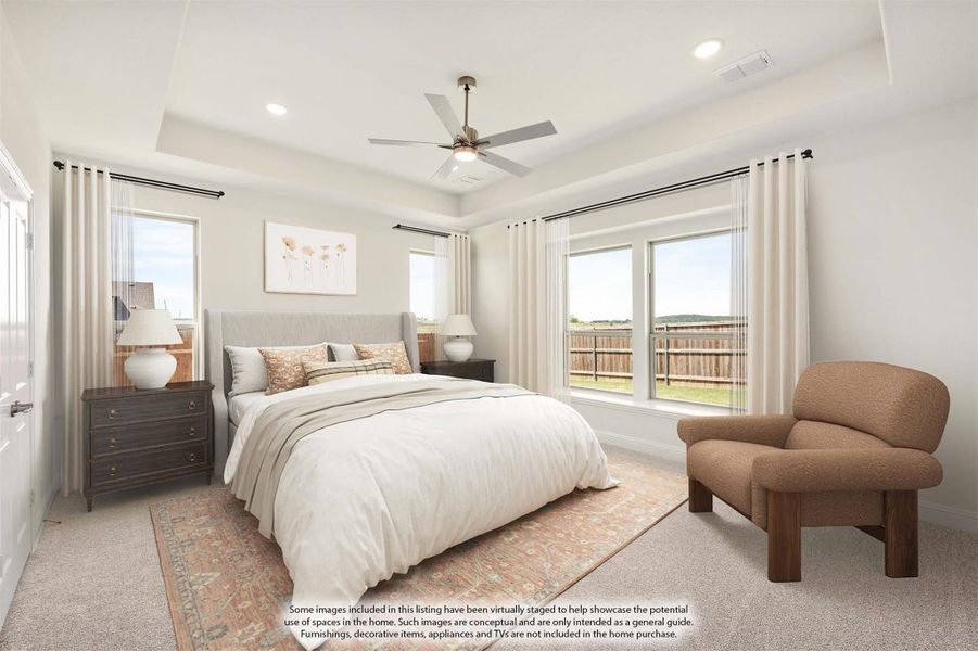 Bedroom with tray ceiling, ceiling fan, large windows, and neutral carpet flooring Bedroom with tray ceiling, ceiling fan, large windows, and neutral carpet flooring