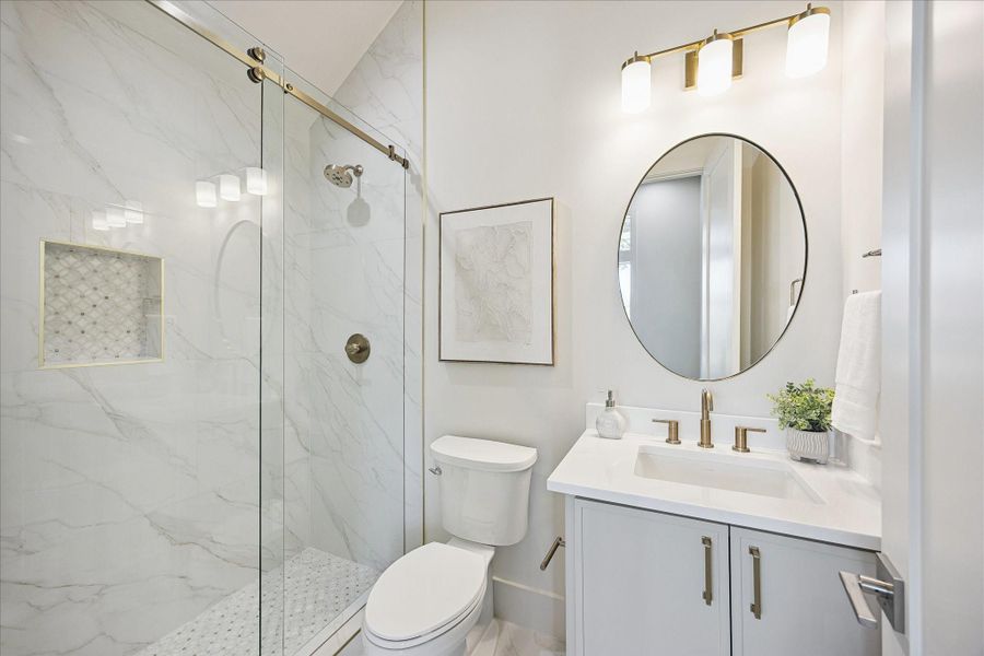 First floor ensuite located in study or 5th bedroom adds valuable flexibility for overnight guests, with a glass enclosed walk-in shower, sleek vanity and polished finishes. With an additional powder bath downstairs keeps everyday living and entertaining easy.