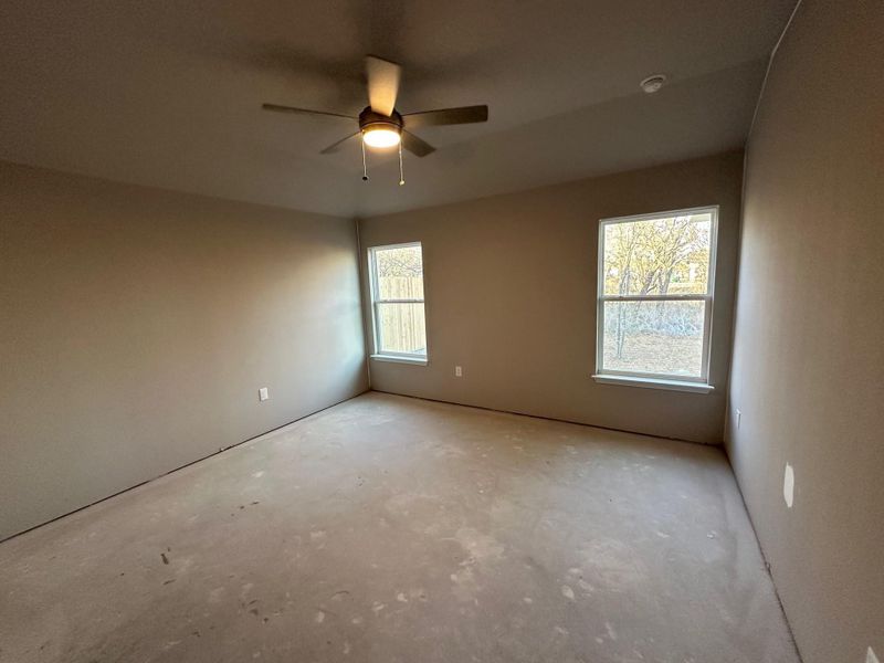 Empty room with ceiling fan and a healthy amount of sunlight