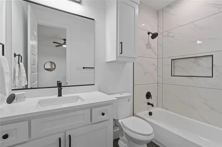 Full bathroom featuring vanity, shower / tub combination, and ceiling fan