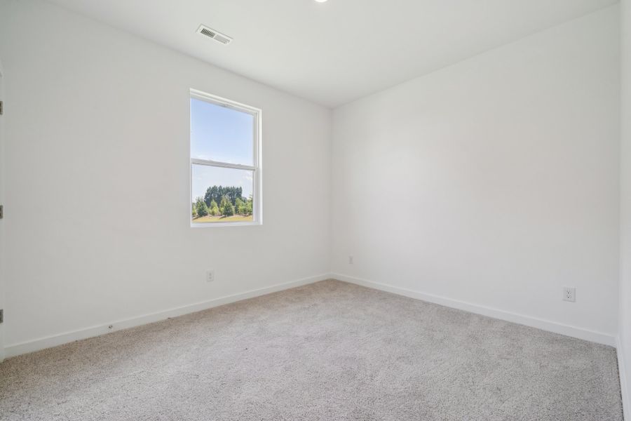 A room with a window and a white wall.
