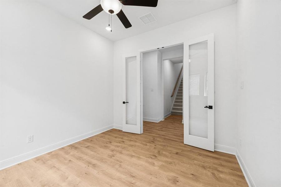 Unfurnished bedroom featuring light wood-style flooring and a ceiling fan Unfurnished bedroom featuring light wood-style flooring and a ceiling fan