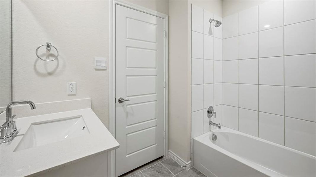 Full bath with bathtub / shower combination, vanity, and light tile patterned floors Full bath with bathtub / shower combination, vanity, and light tile patterned floors