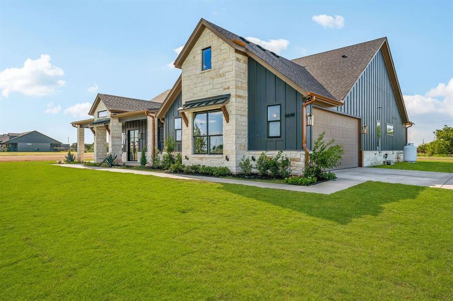 View of front of home featuring a garage and a front lawn