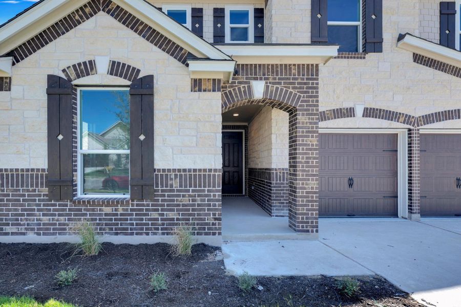 Front exterior of a new home in Salerno - Classic Collection, Round Rock, TX, highlighting curb appeal (Image 21). Front exterior of a new home in Salerno - Classic Collection, Round Rock, TX, highlighting curb appeal (Image 21).