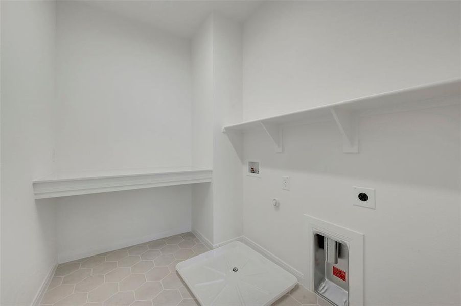 Utility room featuring hexagonal floor tiling, white walls, and built-in shelving