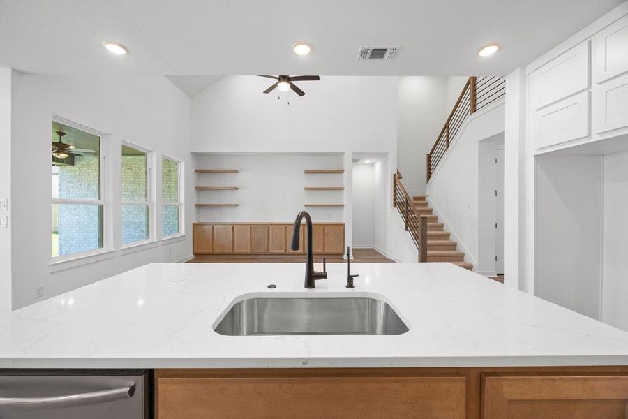 Kitchen with recessed lighting, light stone counters, a ceiling fan, and a kitchen island with sink Kitchen with recessed lighting, light stone counters, a ceiling fan, and a kitchen island with sink