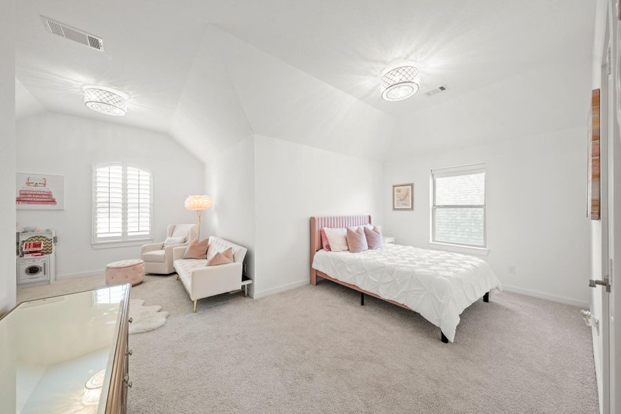 Off the game room is this enormous 22’ x 20’ suite featuring space for a bed with a remote controlled roller shade, plus a separate sitting area with an arched window with plantation shutters.
