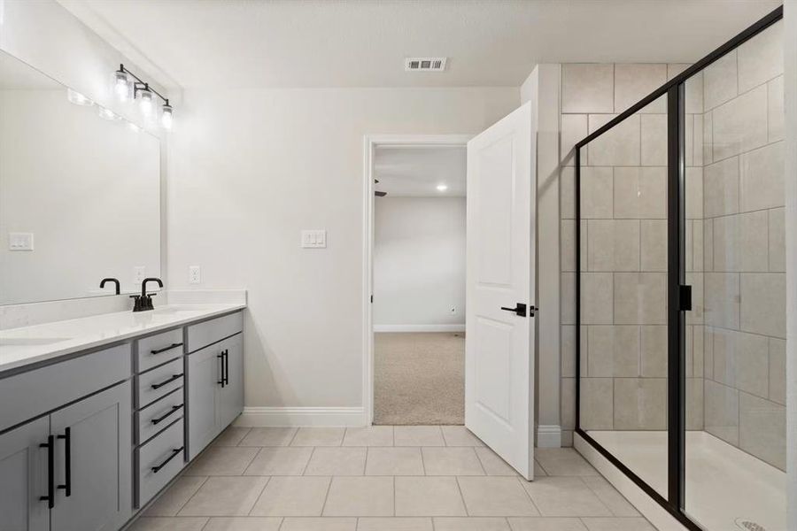 Bathroom with vanity, tile patterned floors, and walk in shower