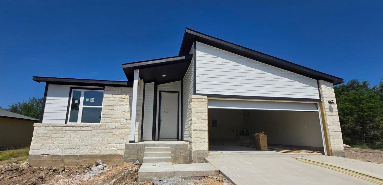 View of front of home with an attached garage, stone siding, and driveway View of front of home with an attached garage, stone siding, and driveway