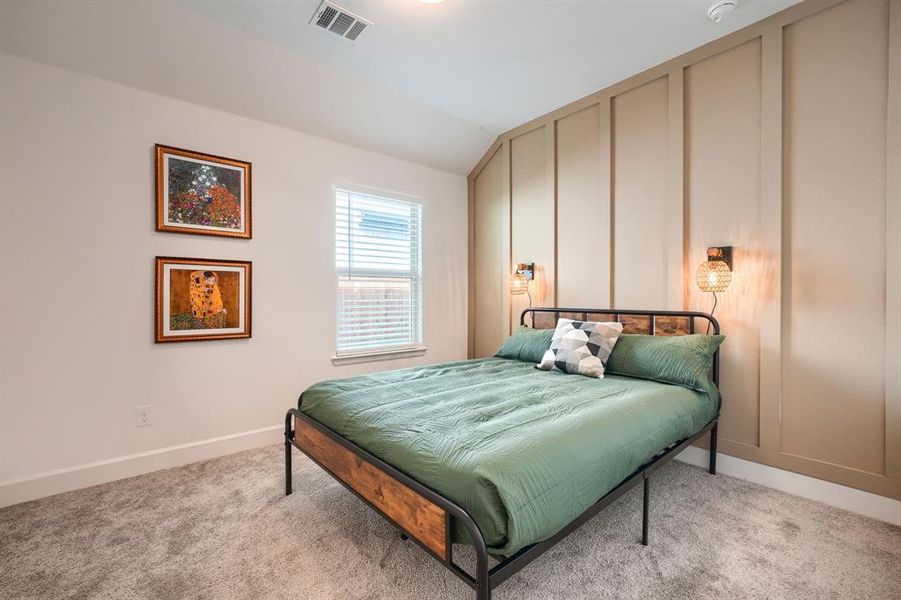 Carpeted bedroom featuring vaulted ceiling