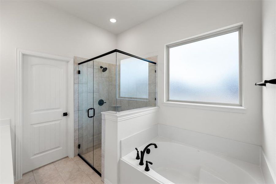 Bathroom with a shower stall and a bath