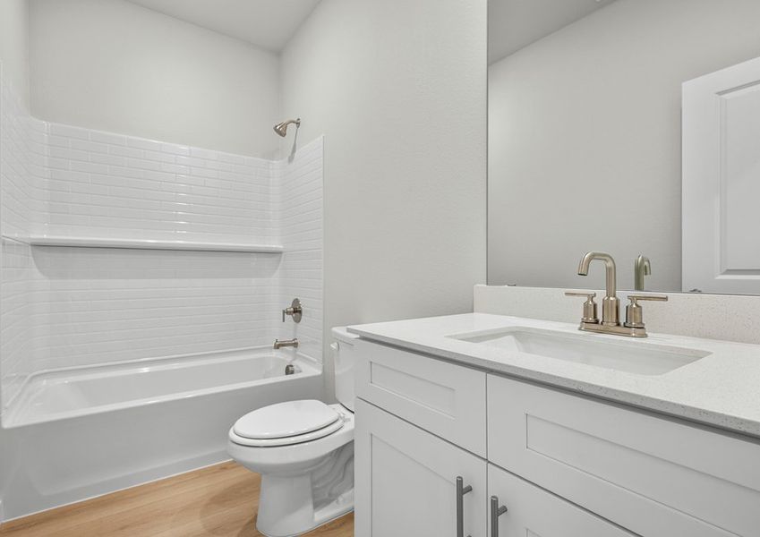 Secondary bath with white cabinet vanity and shower/tub combo.