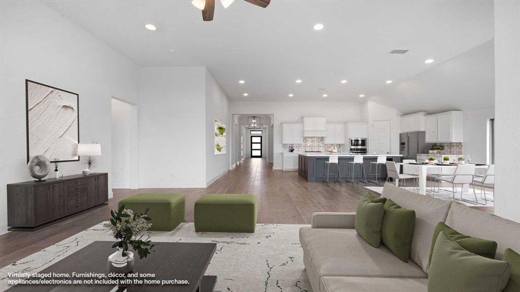 Living area featuring light wood finished floors, visible vents, high vaulted ceiling, and recessed lighting