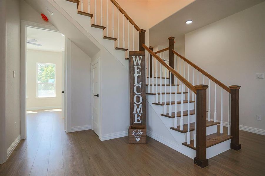 Stairway featuring hardwood / wood-style floors vaulted ceilings.