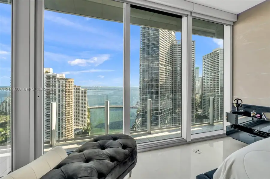 Floor-to-ceiling windows, white tile flooring, and integrated balcony access with glass railings Floor-to-ceiling windows, white tile flooring, and integrated balcony access with glass railings