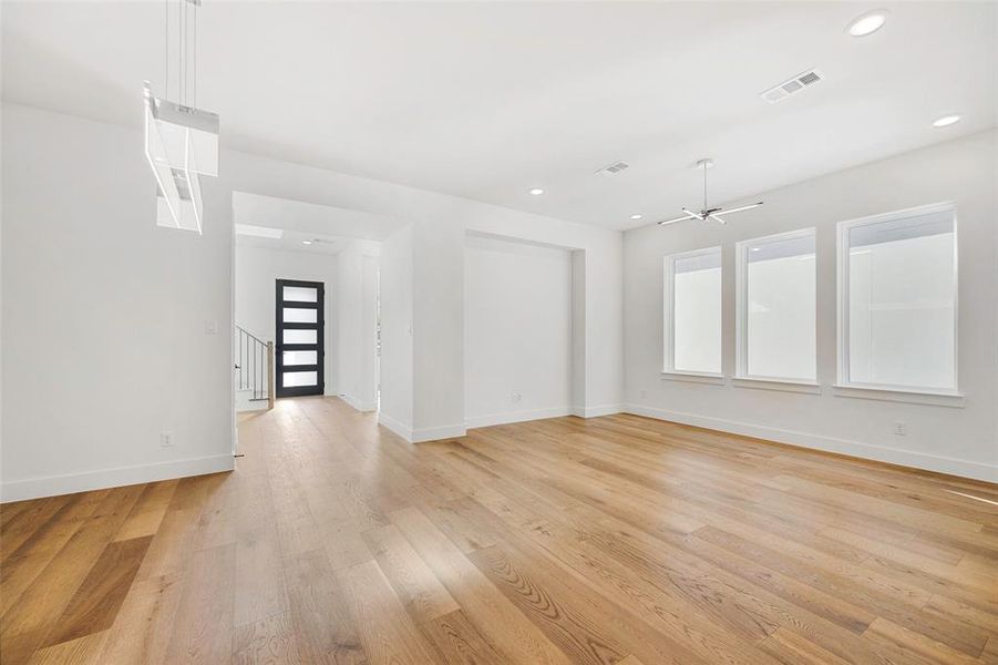 Unfurnished room with light wood-type flooring, visible vents, baseboards, and recessed lighting