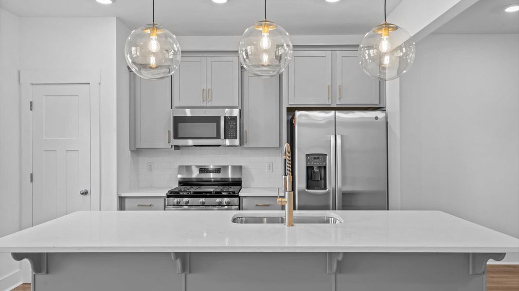 Elegant kitchen with large island and pendant lighting in this first-class DRB Homes design at Silo Ridge