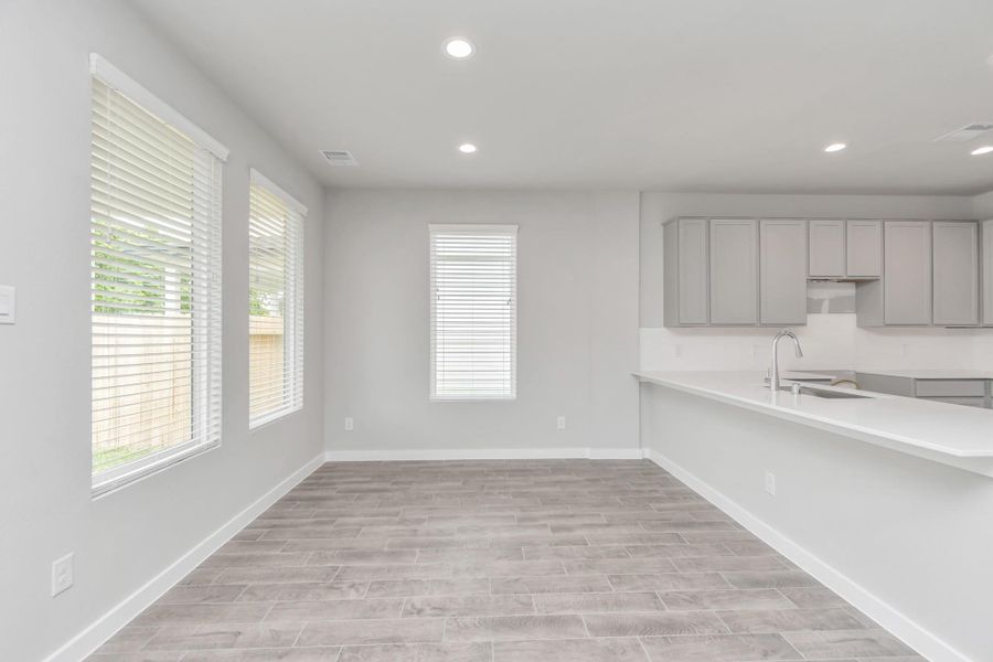 Enjoy breakfast with ease in the connected and cozy breakfast area, seamlessly integrated with the kitchen for utmost convenience. Step through the back door for a breath of fresh air onto the covered patio, extending your living space to the outdoors. Sample photo of completed home with similar floor plan. Actual colors and selections may vary.