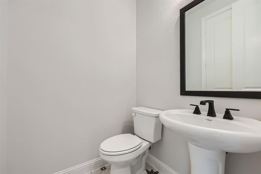 Bathroom featuring sink, tile patterned floors, and toilet