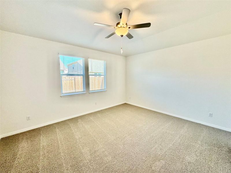 Carpeted empty room with baseboards and ceiling fan