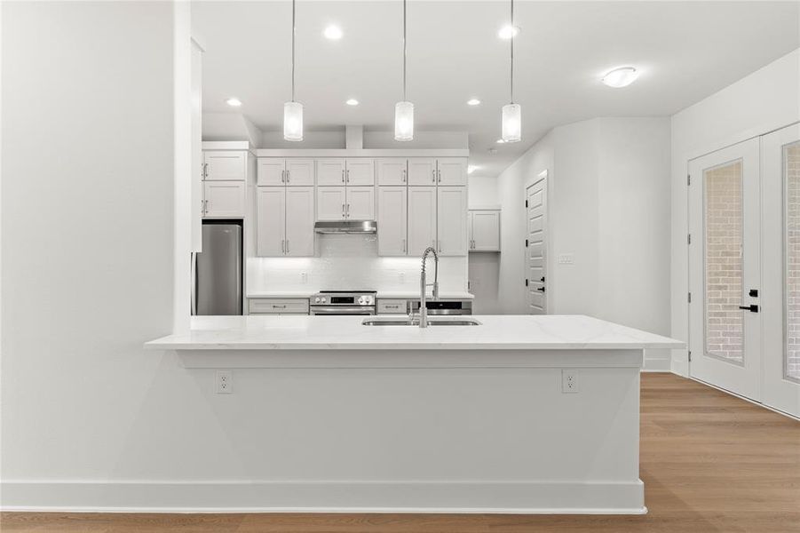 Kitchen with white cabinets, tasteful backsplash, french doors, light wood-type flooring, and recessed lighting Kitchen with white cabinets, tasteful backsplash, french doors, light wood-type flooring, and recessed lighting