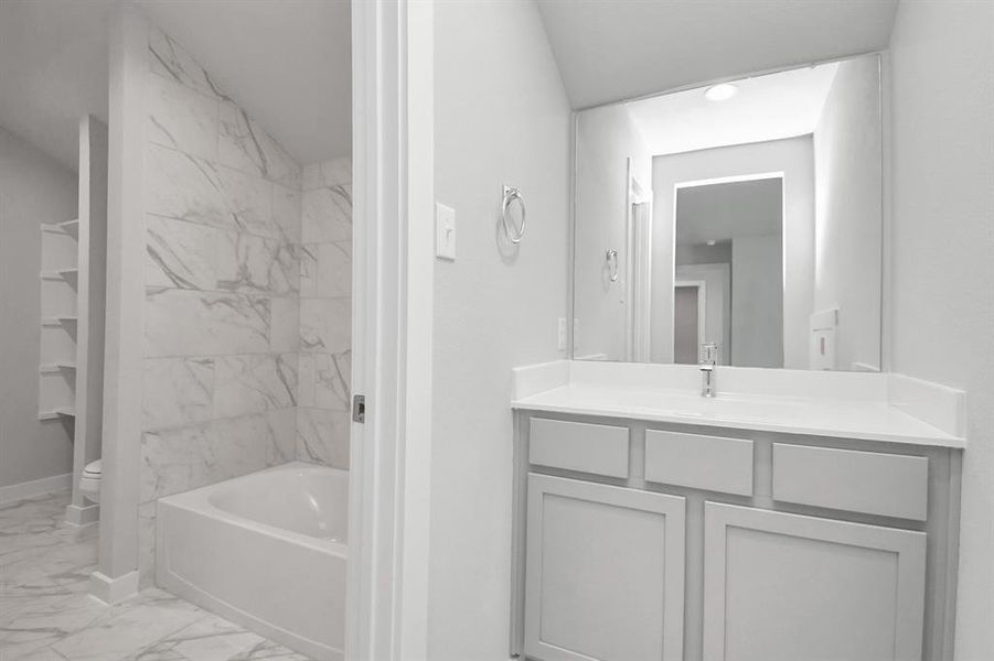 Experience convenience in the secondary bathroom, designed for Jack and Jill arrangements, now with a separate vanity area. Sample photo of completed home with same plan. Actual colors and selections may vary.