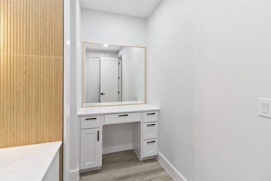 Bathroom featuring light wood-style flooring, vanity, and a closet