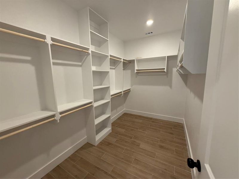 Walk in closet featuring wood tiled floors Walk in closet featuring wood tiled floors
