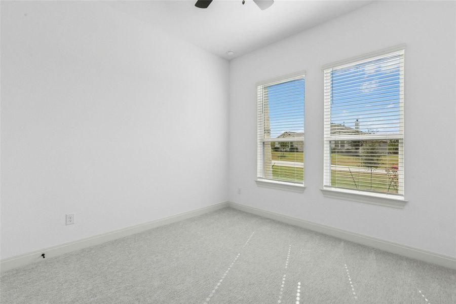 Carpeted spare room featuring baseboards and ceiling fan Carpeted spare room featuring baseboards and ceiling fan