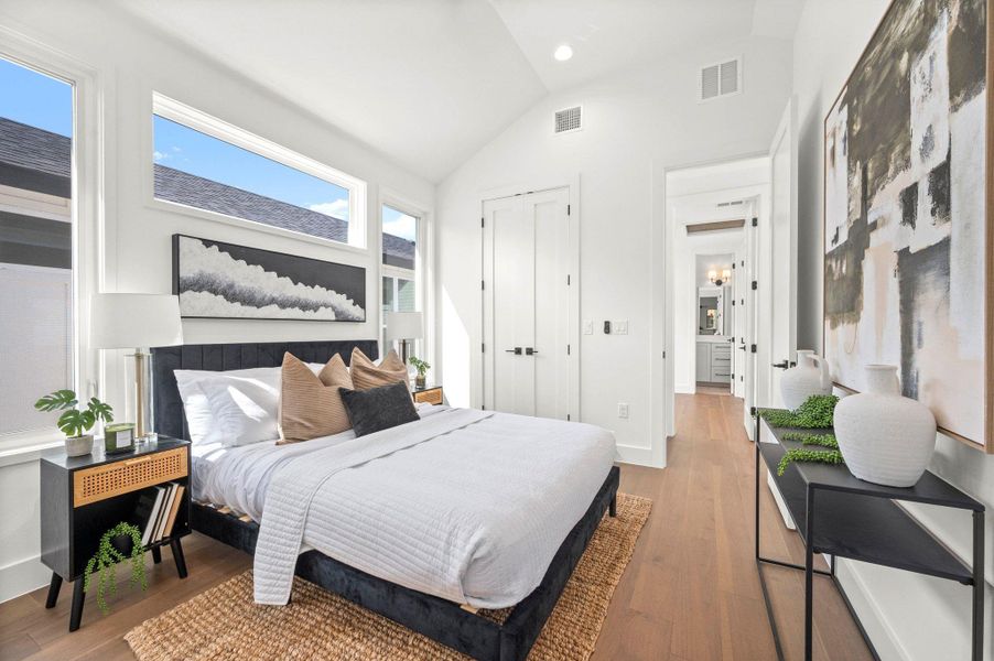 Bedroom featuring vaulted ceiling, wood finished floors, a closet, and recessed lighting