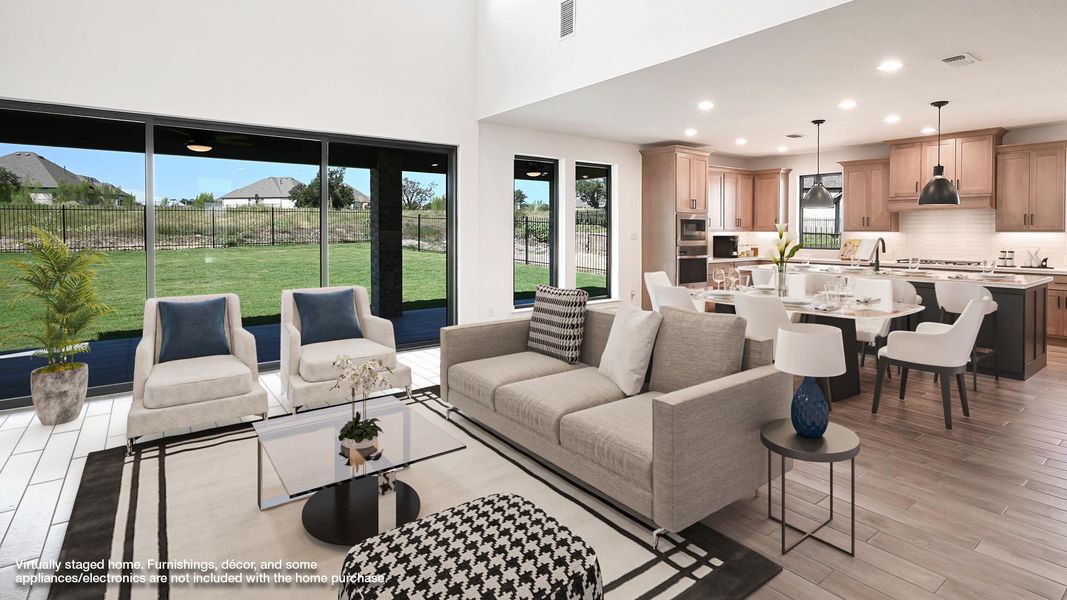 Living area featuring recessed lighting, light wood-style flooring, and a towering ceiling Living area featuring recessed lighting, light wood-style flooring, and a towering ceiling
