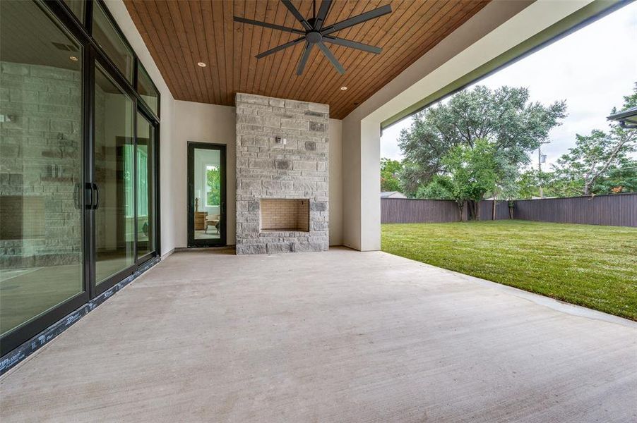 View of patio / terrace featuring an outdoor stone fireplace and ceiling fan