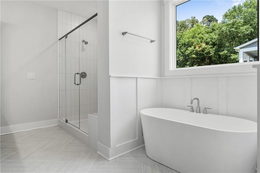 A freestanding soaking tub and glass-enclosed show A freestanding soaking tub and glass-enclosed show
