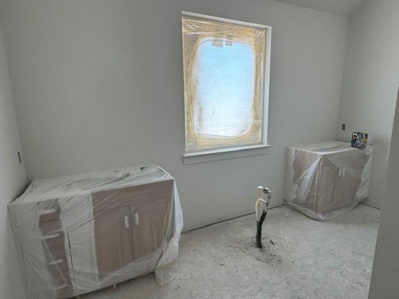 A well-lit bathroom space, awaiting its final fixtures, offers ample design potential. A well-lit bathroom space, awaiting its final fixtures, offers ample design potential.