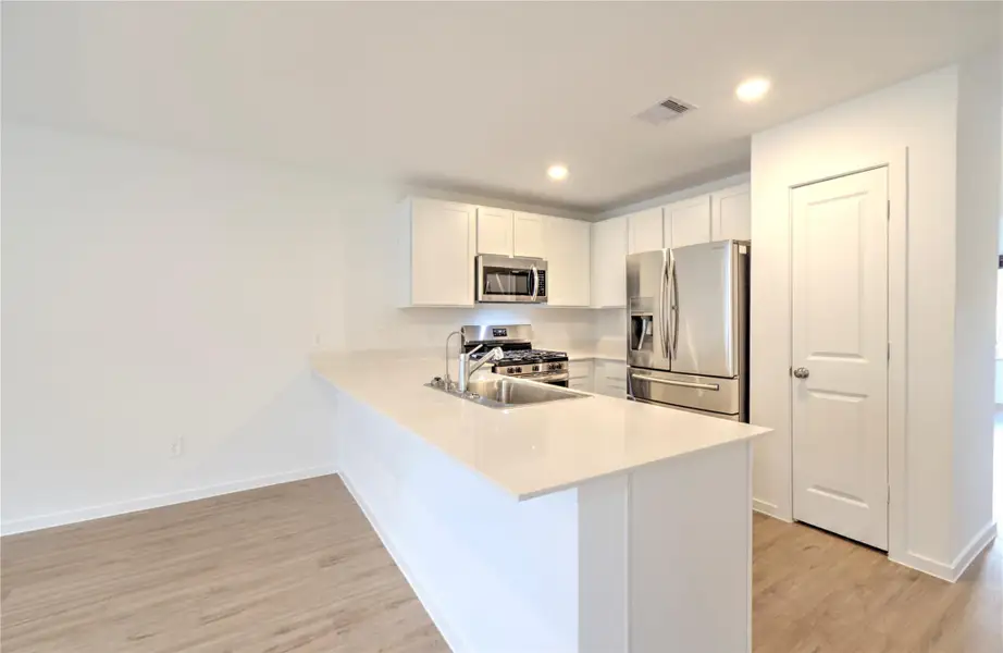 Well appointed kitchen with generous cabinet space, large sink, stainless steel appliances including a gas range.
