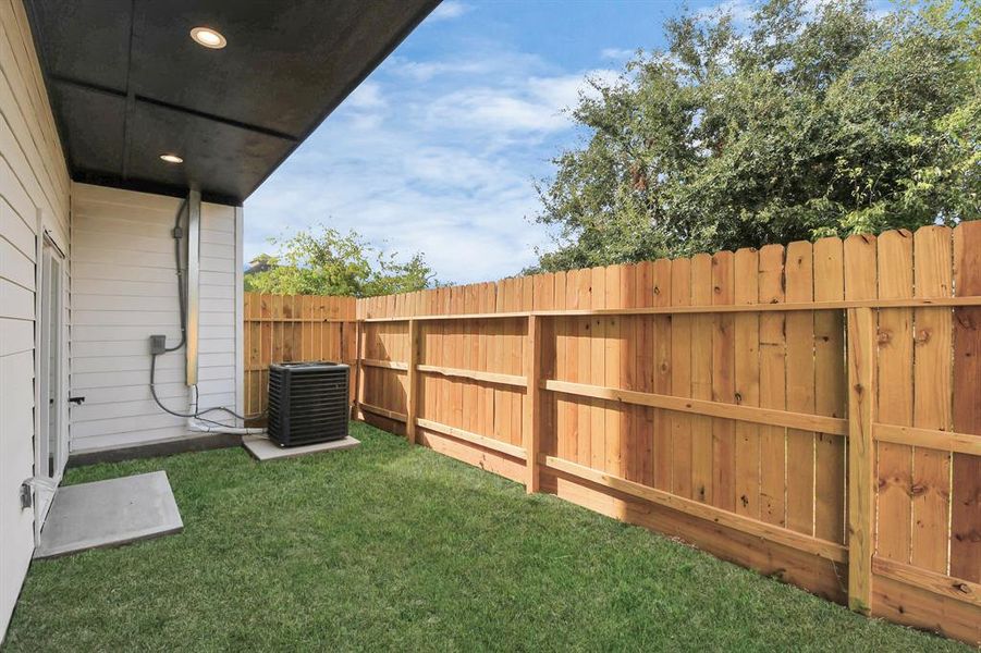 This cozy side yard offers a private outdoor space with a well-maintained lawn and a high wooden fence for added privacy. Situated adjacent to a room with direct access, it’s ideal for enjoying fresh air right outside the home.