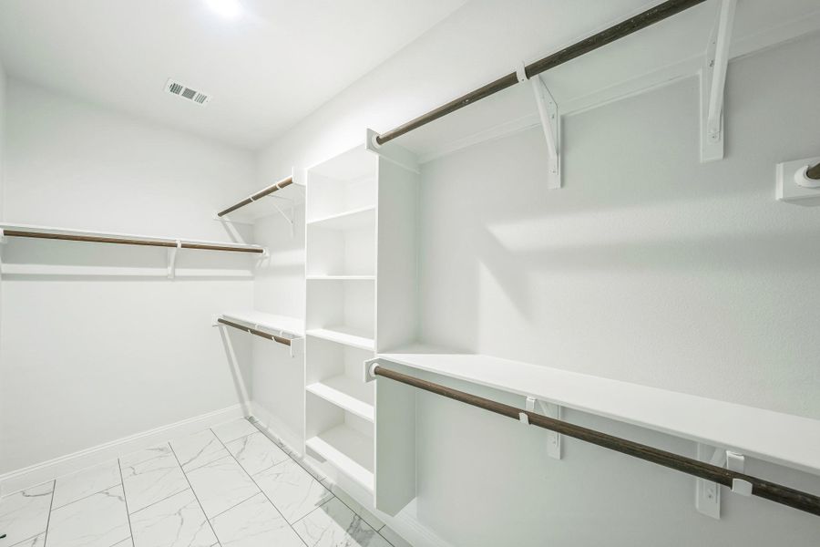 Spacious closet with light marble finish floors