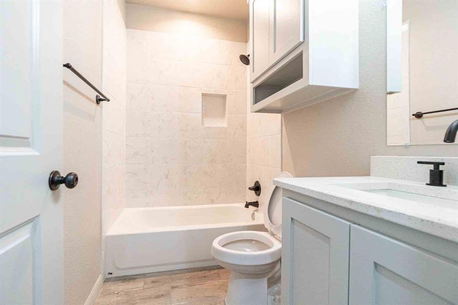 Full bathroom with vanity, bathing tub / shower combination, and light wood-type flooring