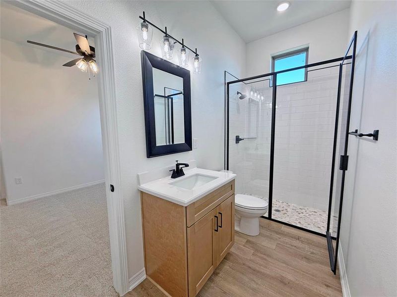 Bathroom featuring a stall shower, vanity, and light wood-style flooring